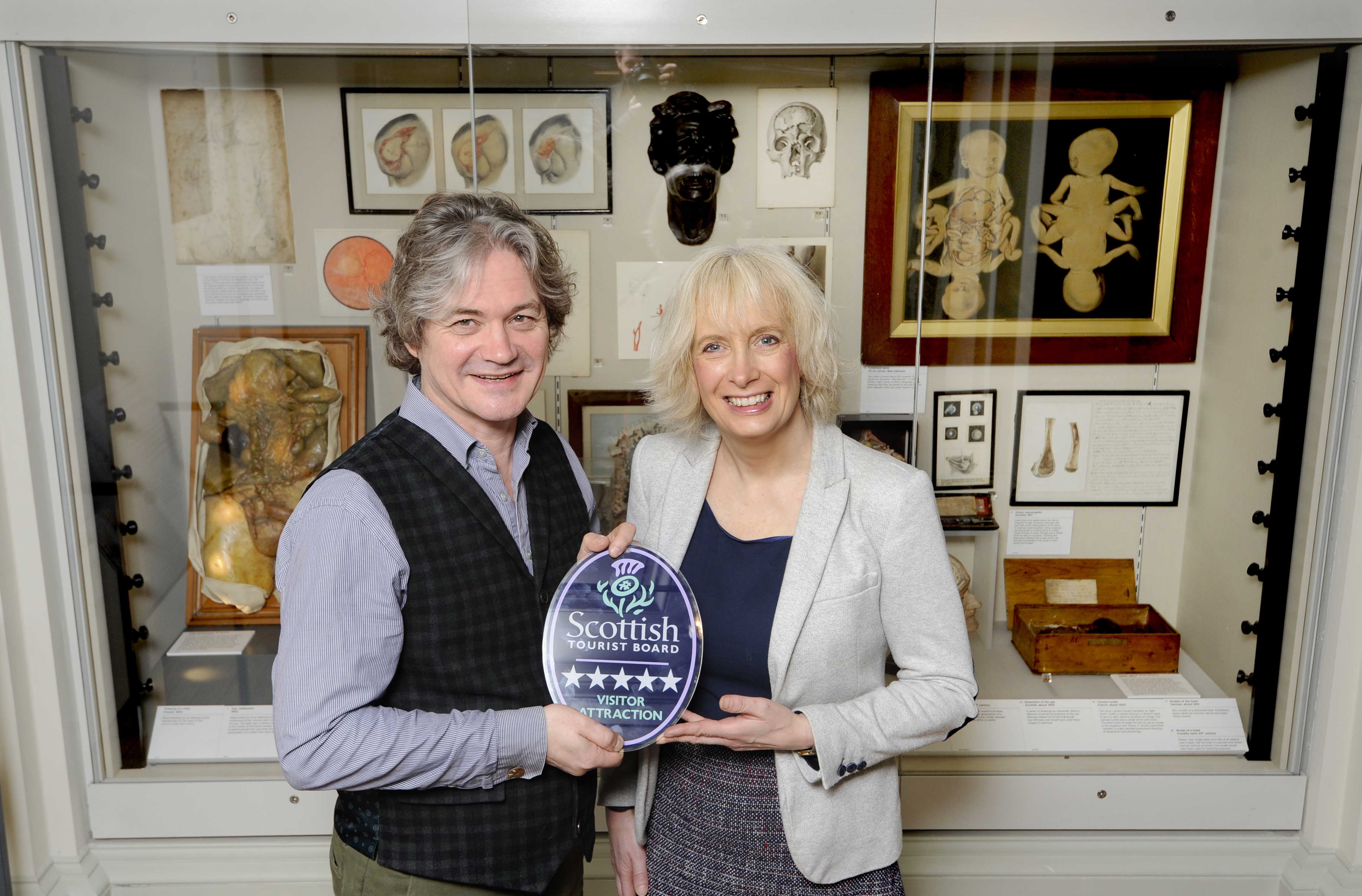 VisitScotland Regional Director, Manuela Calchini (right), presents Chris Henry (left), Director of Heritage at The Royal College of Surgeons of Edinburgh, with Surgeons’’ Hall Museum’s Five Star Quality Assurance award